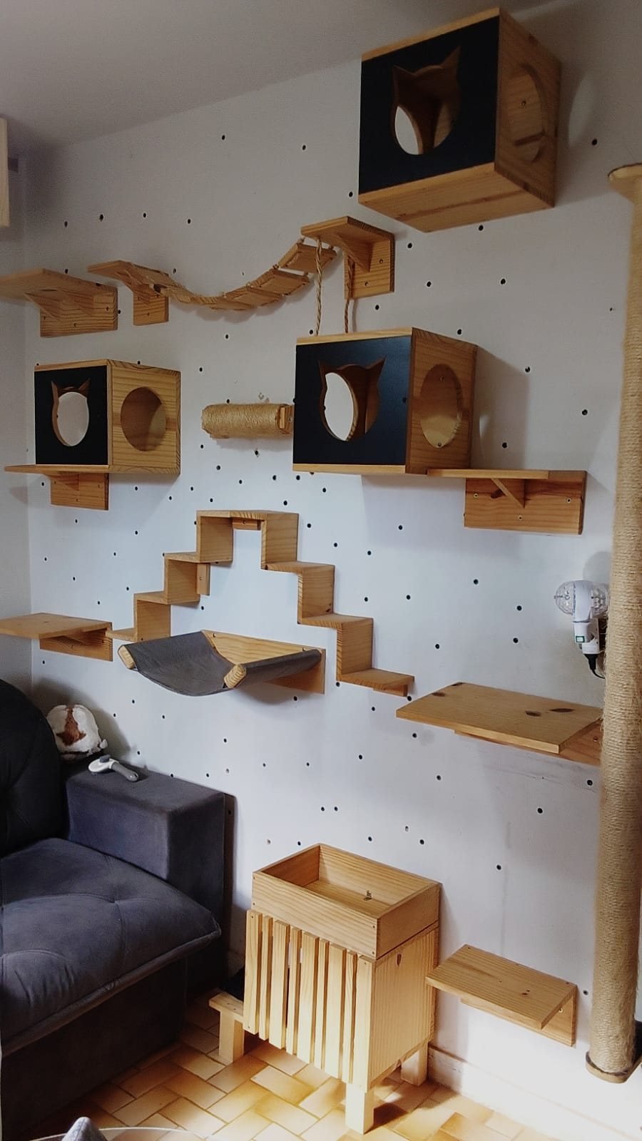 Parede de sala com nichos, ponte de corda, arranhador, escadinha, rede, prateleiras e poste de sisal feitos pela Gato Rústico
